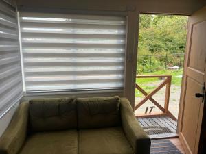 een bank voor een raam met een rolgordijn bij CASA DEL CENTRo in Quellón