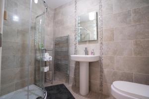 een badkamer met een wastafel en een douche bij Rest a While in Bushmills