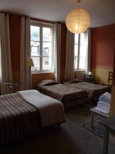Habitación de hotel con 2 camas y lámpara de araña. en Hotel Henri IV en Saint-Valery-en-Caux