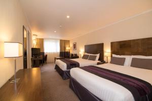 a hotel room with two beds and a desk at Regency Park Hotel, Health Club & Spa in Newbury +35 photos