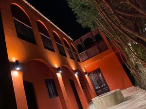 un edificio arancione con una porta di notte di iBiZa Hostel a Beni Suef