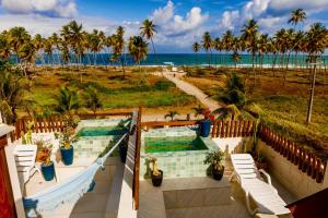 ein Balkon mit zwei Swimmingpools und einem Strand in der Unterkunft Reserva do Paiva suites in Cabo de Santo Agostinho