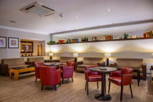 a restaurant with tables and chairs and a couch at Regency Park Hotel, Health Club & Spa in Newbury