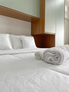 a white bed with two rolled towels on it at Flat Apartamento Av Esmeralda em Marília in Marília