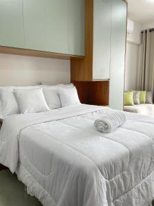 a bedroom with a white bed with white sheets at Flat Apartamento Av Esmeralda em Marília in Marília
