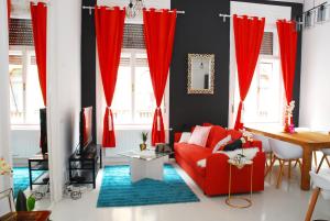 ブダペストにあるAnti-Cafe Kazinczyのリビングルーム(赤いカーテン、赤いソファ付)