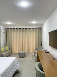 a bedroom with a bed and a flat screen tv at Flat Apartamento Av Esmeralda em Marília in Marília