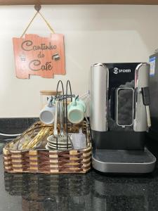 a coffee maker in a basket on a counter at Flat Apartamento Av Esmeralda em Marília in Marília