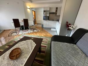 a living room with a couch and a table at Golden Lilly Apartment in Bihać