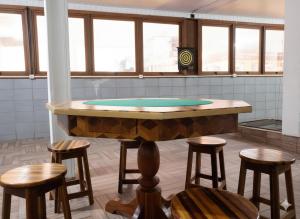 a ping pong table in a room with stools at Ap Completo a 5min Centro Eventos/10min praias in Itajaí