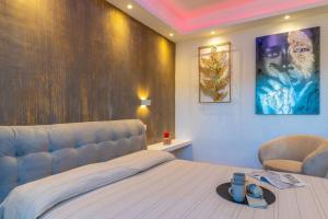 een slaapkamer met een kingsize bed en een stoel bij la maison dorée in Olbia