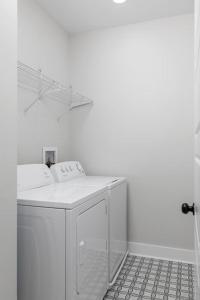 een witte wasmachine in een witte kamer bij Springfield Haven in Springfield