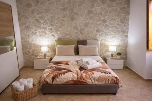 una camera da letto con un letto con asciugamani sopra di Le Stanze Della Castellana a Bosa