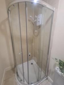a shower with a glass door in a bathroom at West Park One Bedroom in South Shields