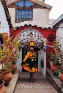 een vrouw staat in de deuropening van een gebouw bij Casa María Victoria 