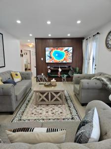 ein Wohnzimmer mit zwei Sofas und einem Fernseher in der Unterkunft Riverfront Cottage Sauna Canoe Included Kids Playroom Nature Escape in Wasaga Beach