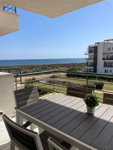 a wooden table and chairs on a balcony with the ocean at Blue Retreat Suites by the Sea in Vokolidha