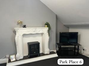 a living room with a fireplace and a tv at Park Place Apartments in Sunderland