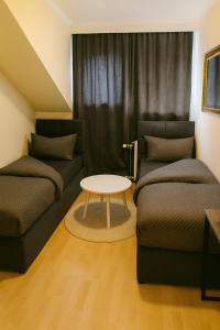 a living room with two couches and a table at The Soho Altstadt Relais in Düsseldorf