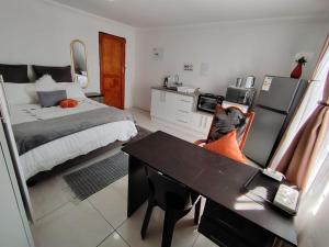 a bedroom with a bed and a desk in it at Mathwala Guesthouse in Vanderbijlpark
