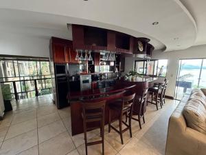 een keuken met een bar met stoelen en een bank bij Mi Casa in Hartbeespoort +34 foto's