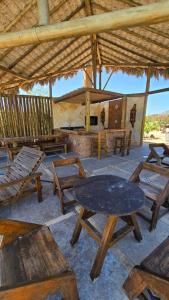 eine Gruppe von Picknicktischen und Stühlen unter einem Dach in der Unterkunft Chale Ville Maramar 401 in Luis Correia + 12 Fotos
