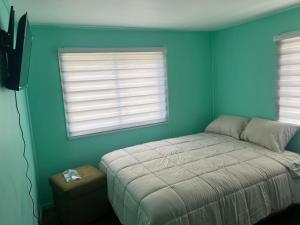 een slaapkamer met een bed en twee ramen bij CASA DEL CENTRo 2 in Quellón