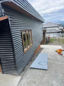 een metalen gebouw met een raam aan de zijkant bij CASA DEL CENTRo 2 in Quellón
