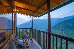 een balkon met stoelen en uitzicht op de bergen bij Indulge Ramgarh by PACK in Rāmgarh