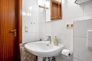 Ferienwohnung Dommel في كوكسهافن: حمام أبيض مع حوض ومرآة +24 صورة