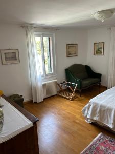 a bedroom with a bed and a chair and a window at La Maison in Mestre