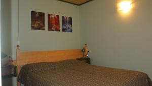 ein Schlafzimmer mit einem Bett und drei Bildern an der Wand in der Unterkunft B & B San Giovanni in Nigola