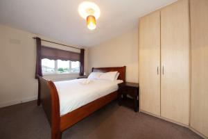een slaapkamer met een bed en een grote kast bij Modern 3BDR property in beautiful Swords Dublin in Swords