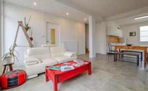 ein Wohnzimmer mit einem weißen Sofa und einem roten Tisch in der Unterkunft Le chaource in Chaource