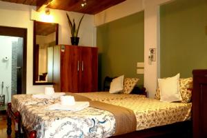 zwei Betten in einem Zimmer mit grünen Wänden in der Unterkunft Ayurprana Marari in Mararikulam