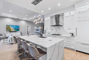 eine weiße Küche mit einer großen Insel in der Mitte in der Unterkunft Spacious Three Bedroom Lakeside Home with Relaxed Coastal Comfort in Palm Beach Shores