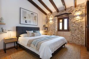 ein Schlafzimmer mit einem Bett und einer Steinwand in der Unterkunft Villa My Love Mallorca in Bunyola