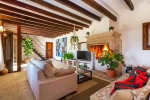 ein Wohnzimmer mit einem großen Steinkamin in der Unterkunft Villa My Love Mallorca in Bunyola