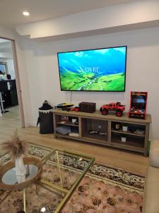 ein Wohnzimmer mit einem Flachbildfernseher an der Wand in der Unterkunft Riverfront Cottage Sauna Canoe Included Kids Playroom Nature Escape in Wasaga Beach