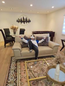 Ein Mann, der auf einer Couch im Wohnzimmer liegt. in der Unterkunft Riverfront Cottage Sauna Canoe Included Kids Playroom Nature Escape in Wasaga Beach + 71 Fotos