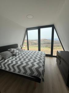 een slaapkamer met een groot bed met een groot raam bij Wine Valley Villas in Lipovac