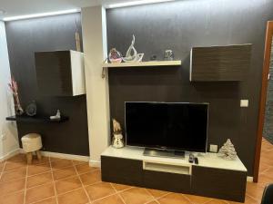 a living room with a flat screen tv on a table at Bird’s Home in Aveiro