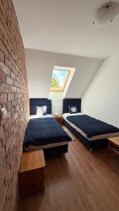 una camera da letto con due letti e un muro di mattoni di Dom murowany Siedlisko a Sarbinowo