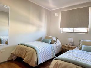 a bedroom with two beds and a window at Arden Haus Estadías boutique Talca in Talca