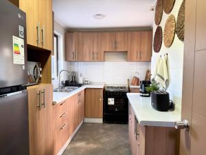 a kitchen with wooden cabinets and a black appliance at Arden Haus Estadías boutique Talca in Talca