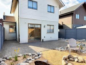 a house with a patio and a chair in front of it at Arden Haus Estadías boutique Talca in Talca