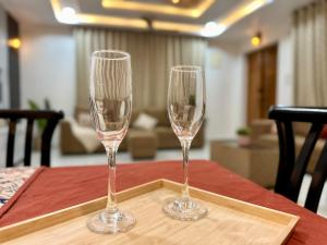 deux coupes de champagne posées sur un plateau en bois sur une table dans l'établissement Novo Stays - Artistic Boho Edition, à Hyderabad