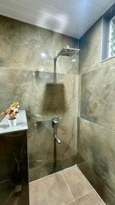une salle de bain avec une douche avec une porte vitrée dans l'établissement Novo Stays - Artistic Boho Edition, à Hyderabad