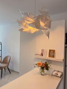 eine Vase mit Blumen auf einer Theke mit einem Licht in der Unterkunft Departamento Sofia Soberana in Bahía Blanca