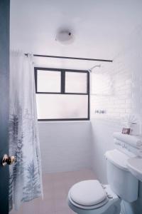 ein Badezimmer mit Toilette und Duschvorhang in der Unterkunft Marqués Oaxaca - Hotel in Oaxaca de Juárez